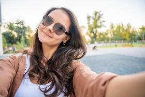 files/young-smiling-woman-in-trendy-summer-clothes-happy-model-posing-in-the-street-at-sunny-day-makes-pov-selfie-in-sunglasses-high-quality-photo.jpg